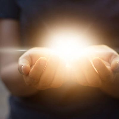 Holding hands open with glowing lights on dark background